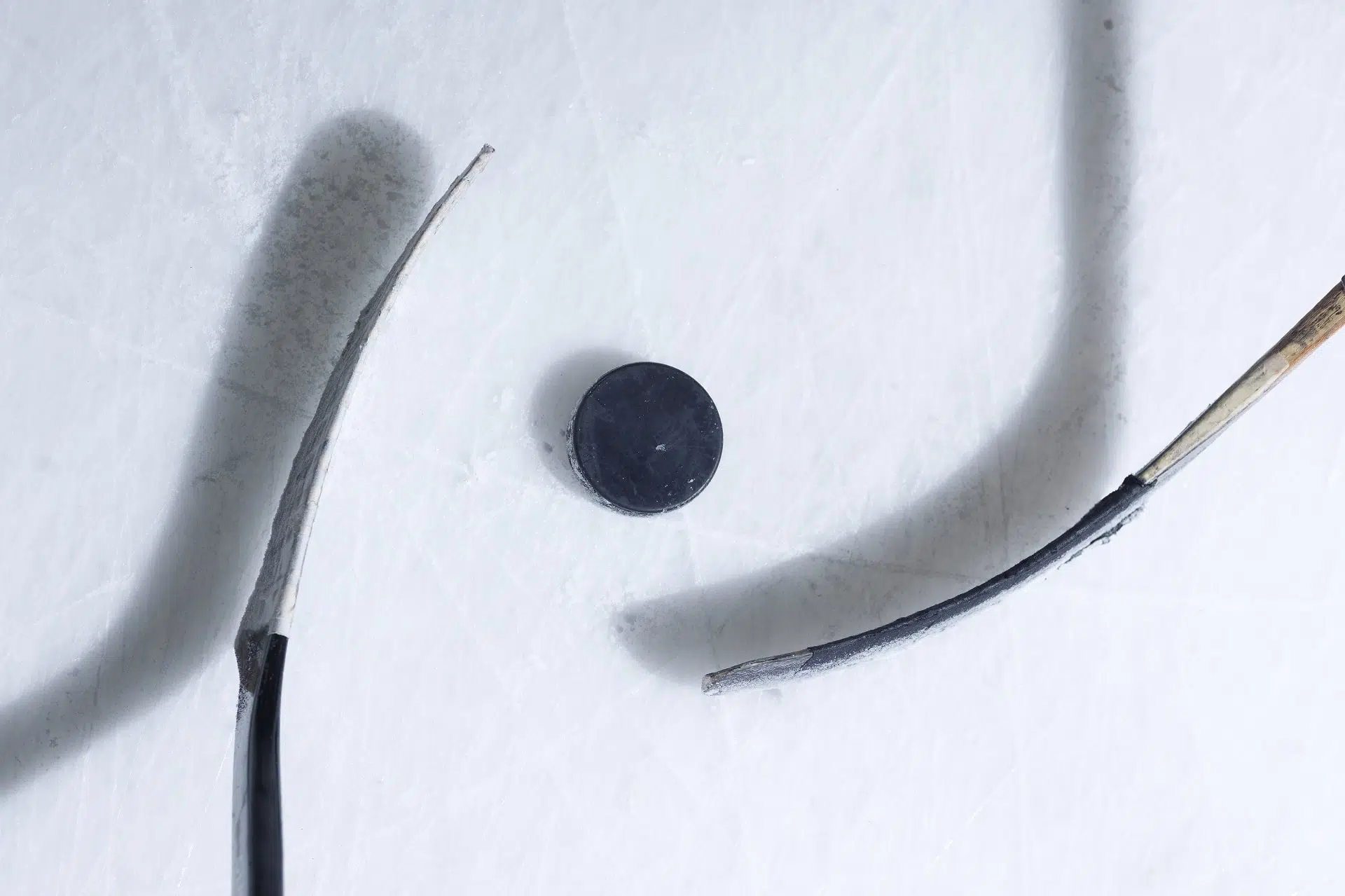 vue de haut de deux bâtons d'hockey avec une rondelle sur la glace