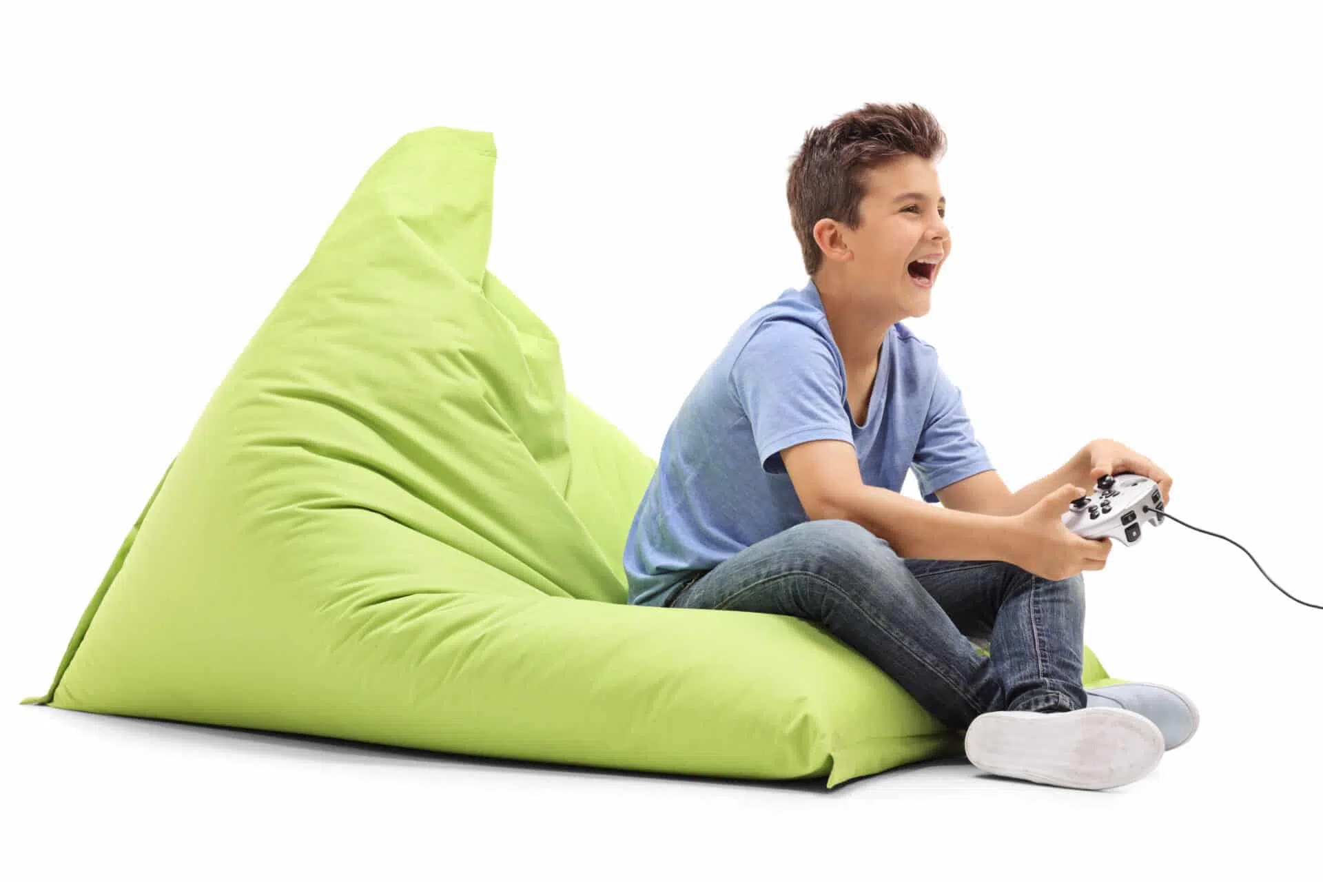 Enfant garçon qui joue à un jeu vidéo assis sur un gros coussin vert lime