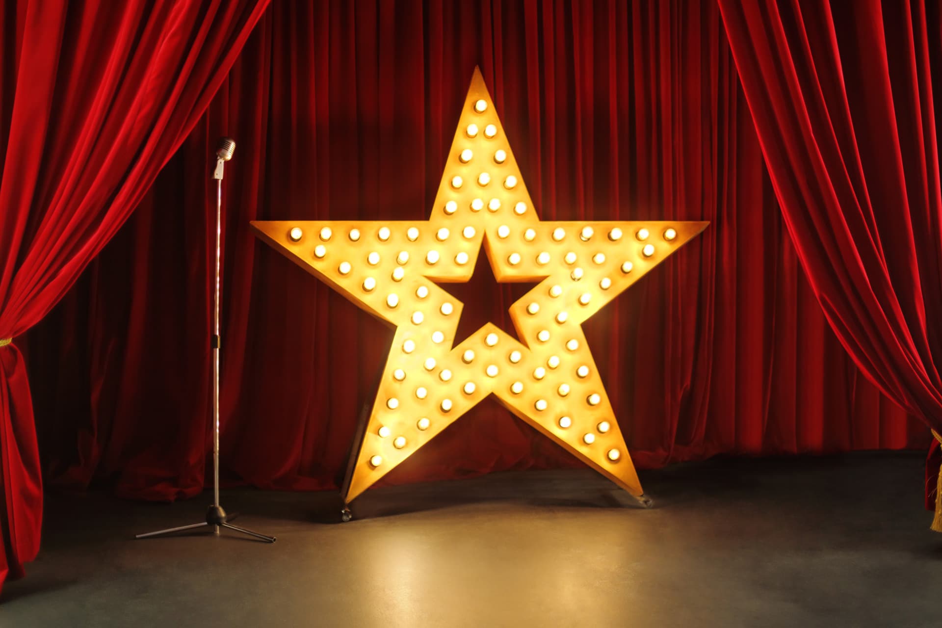 Une étoile lumineuse sur une scène de spectacle avec un micro.