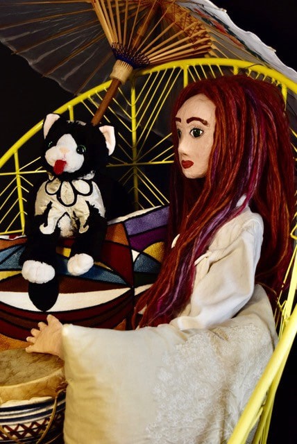 marionnette d'une fillette aux cheveux rouges et d'un chat noir et blanc