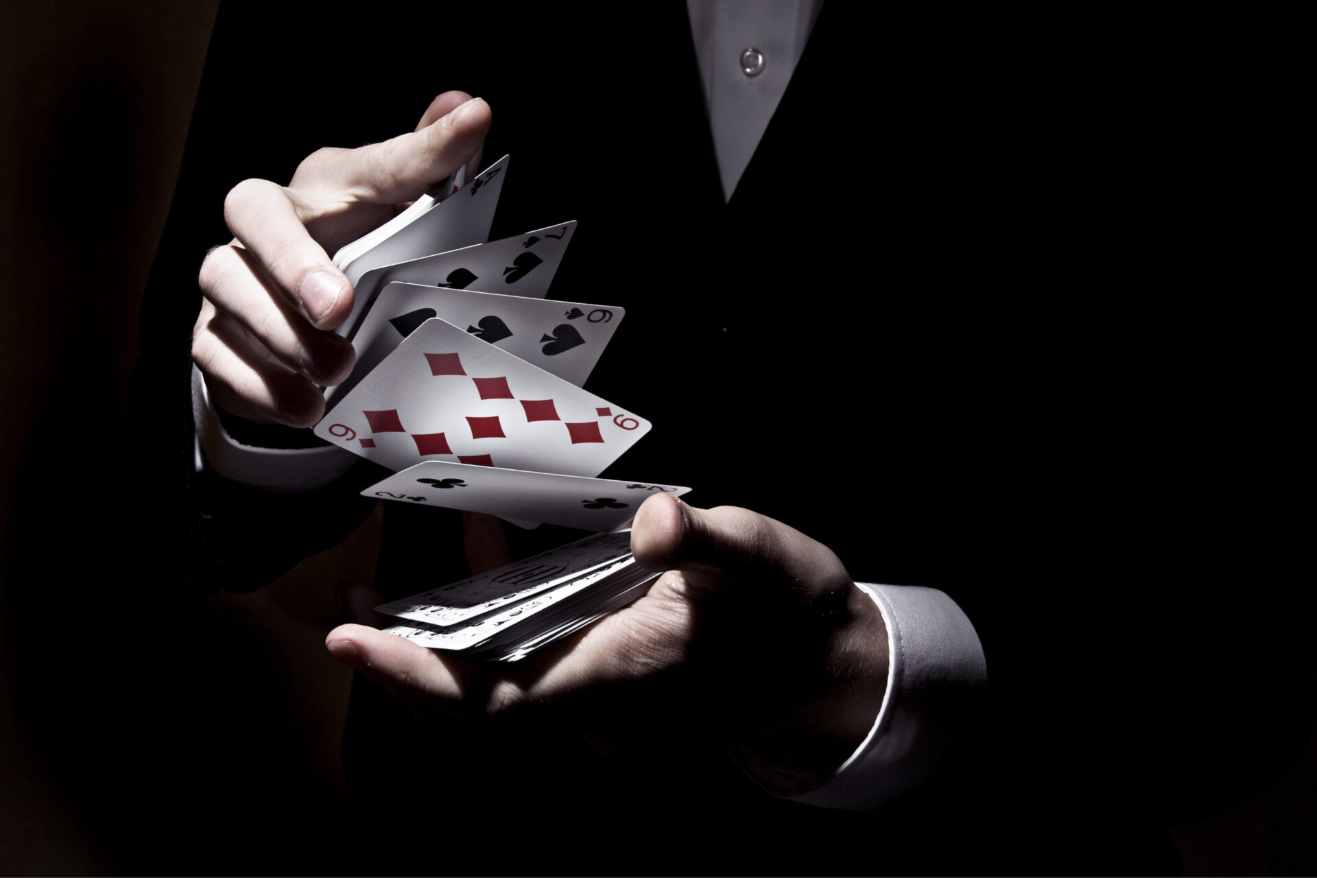 Mains faisant un truc de magie avec des cartes de jeu