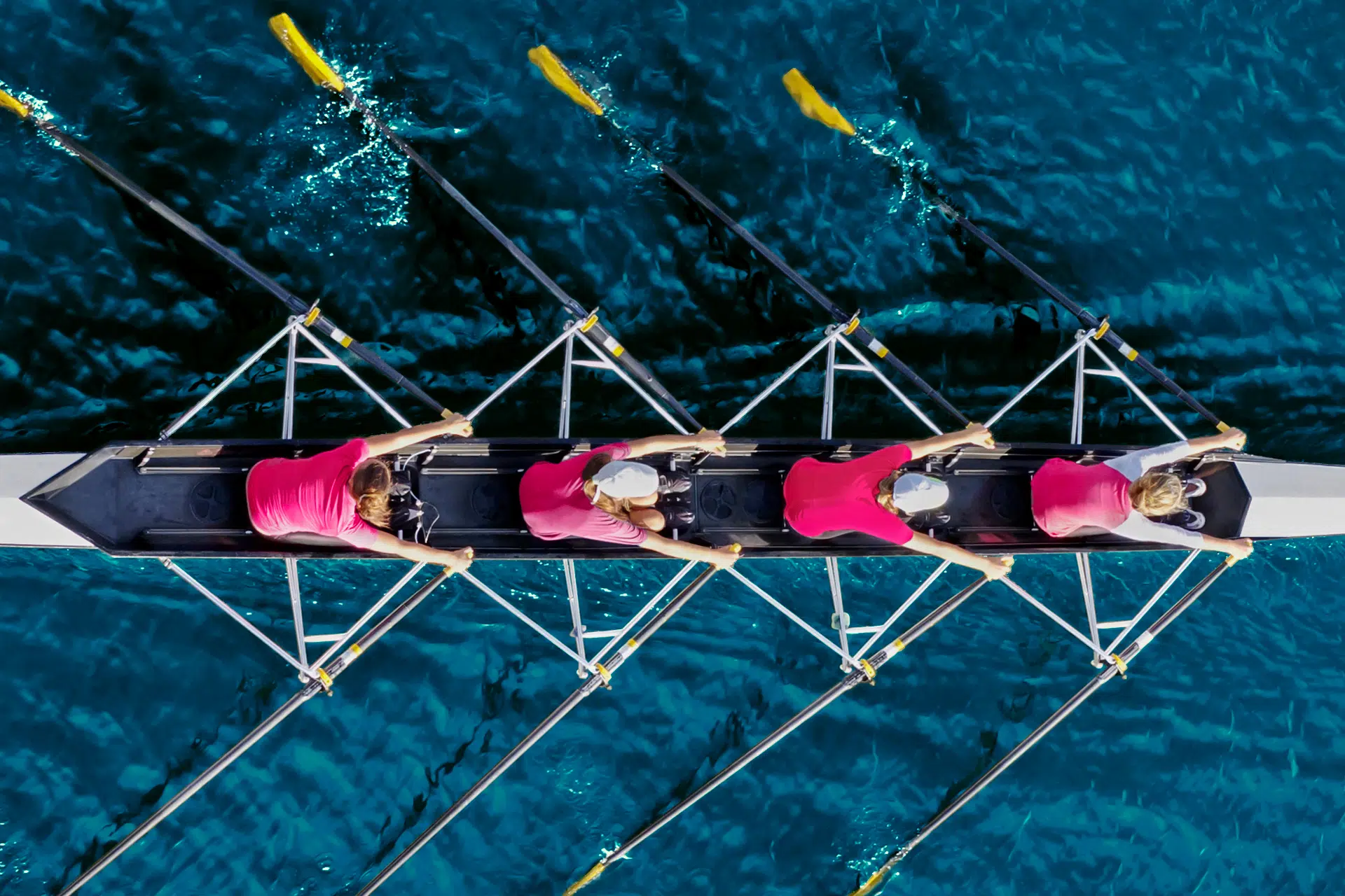 Vue de haut de quatres rameurs dans leur aviron glissant sur l'eau