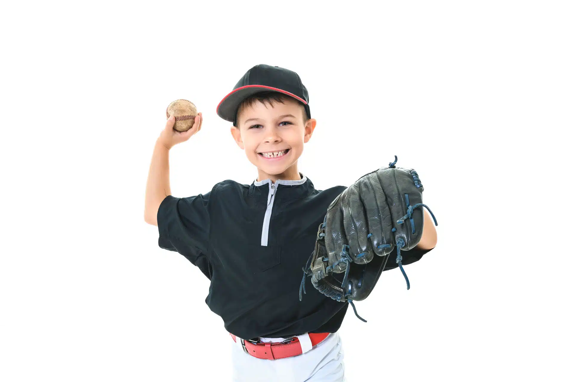 Un jeune garçon tient un gant de baseball et une balle dans ses mains