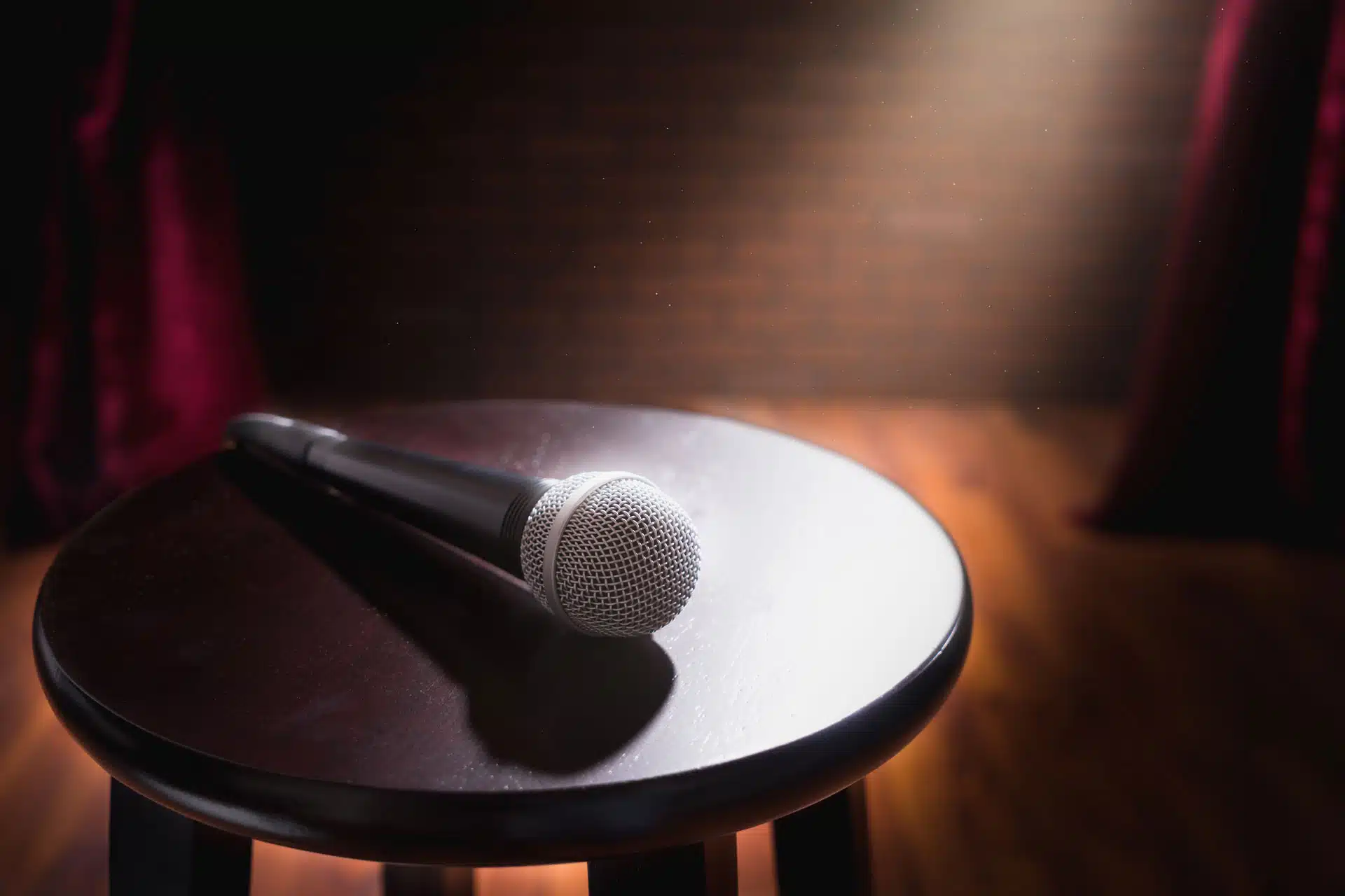 Un micro et un tabouret sur une scène de spectacle